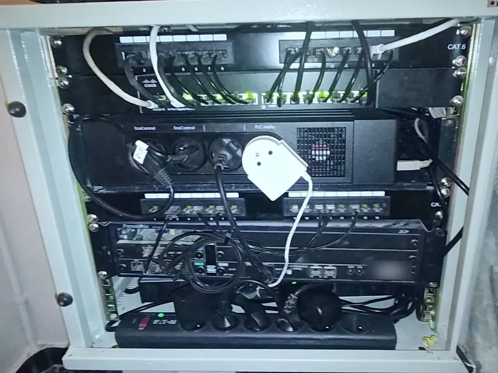 Baie réseau ouverte et rangée : panneaux de brassage, switch Cisco et câbles courts alignés