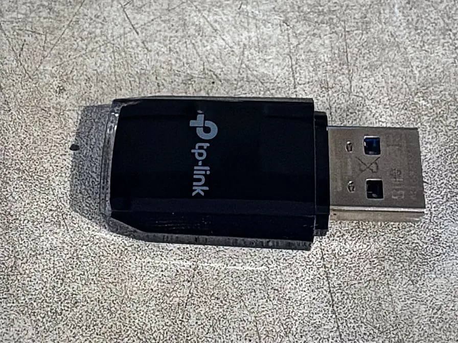 Petite clé Wi-Fi USB TP-Link noire, posée à plat