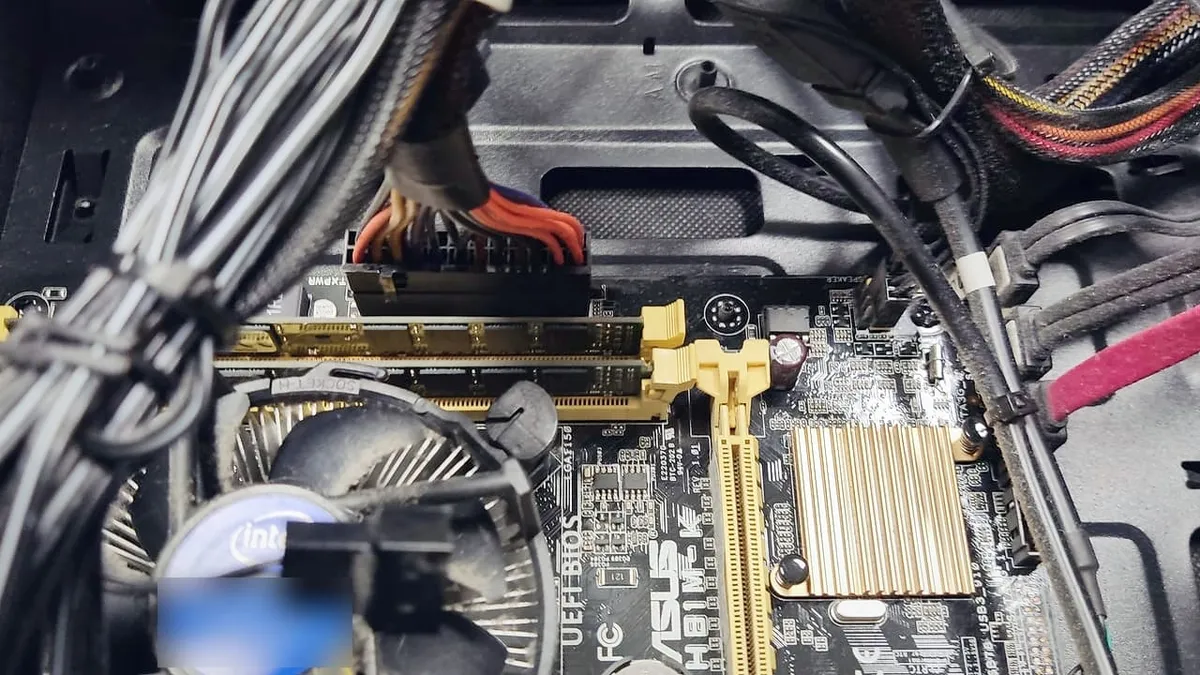 Carte mère ASUS d’un PC de bureau, barrettes de mémoire dans leurs emplacements, ventirad Intel en dessous